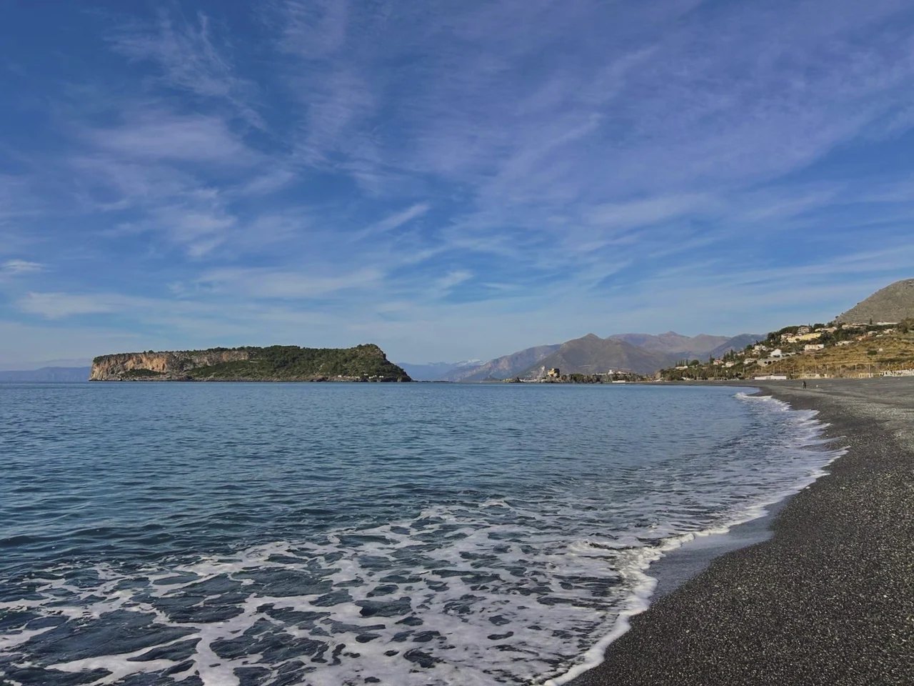 The shore in the evening, with the island of Dino beyond