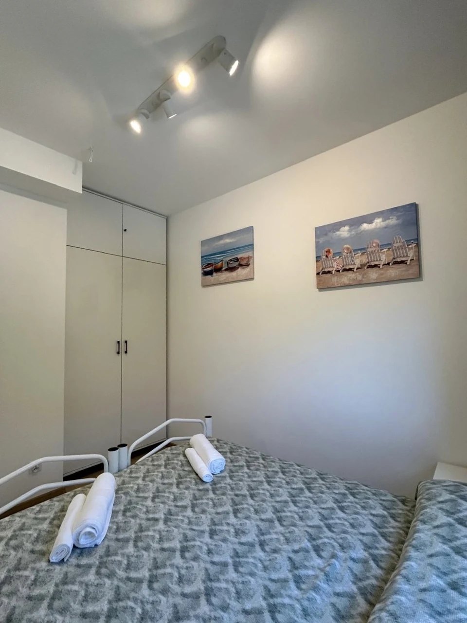 The wardrobe and fresh towels on the bed
